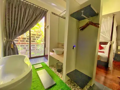 a bathroom with a tub and a sink and a window at Venus Private Pool Kuta By iLys Collection in Kuta