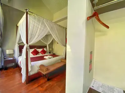 a bedroom with a bed with a canopy at Venus Private Pool Kuta By iLys Collection in Kuta