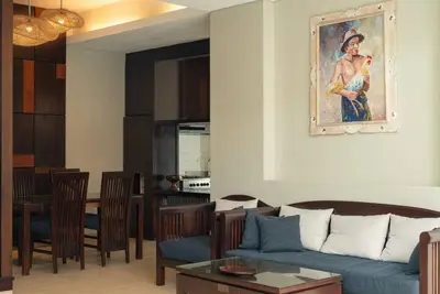 a living room with a blue couch and a dining room at Balinese stile villa in Nusa Dua