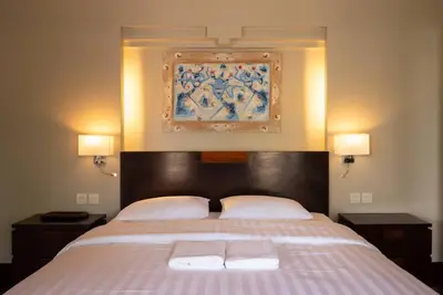 a bedroom with a large bed with two towels on it at Balinese stile villa in Nusa Dua