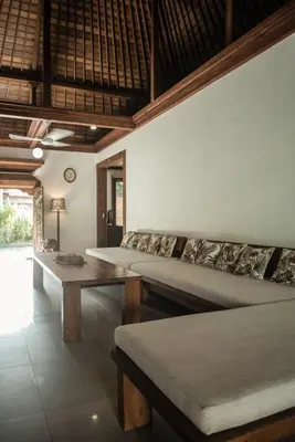 a room with two beds and a table at Segara Beach House Villa - Kuta in Kuta