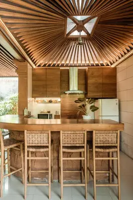a kitchen with a large wooden table and chairs at Segara Beach House Villa - Kuta in Kuta