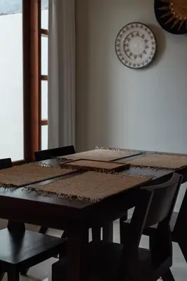 a wooden table with chairs and a clock on the wall at Terrace Mumbul in Nusa Dua