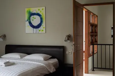 a bedroom with a bed and a painting on the wall at Terrace Mumbul in Nusa Dua