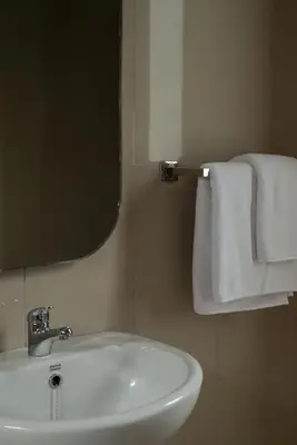 a bathroom with a sink and a mirror and towels at Terrace Mumbul in Nusa Dua