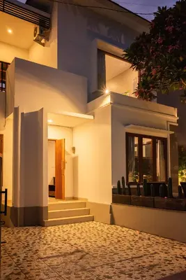 a white house with black chairs in front of it at Terrace Mumbul in Nusa Dua