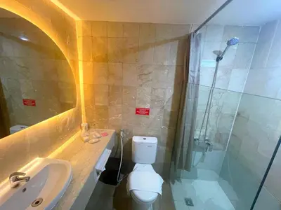a bathroom with a toilet and a sink and a shower at The Tandibayang Hotel & Villas in Legian