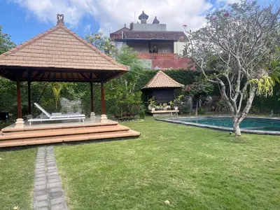 a garden with a gazebo and a swimming pool at Eimas Hive in Kerobokan