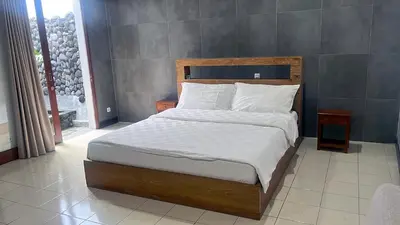 a bed with white sheets and pillows in a bedroom at Eimas Hive in Kerobokan