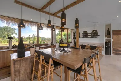 a kitchen and dining room with a wooden table and chairs at Villa Casa Eldorado by BaliSuperHost in Kerobokan