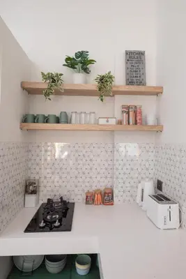 a kitchen with a stove and some shelves at Villa Dimaz in Seminyak