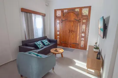 a living room with a couch and a table and a door at Villa Dimaz in Seminyak