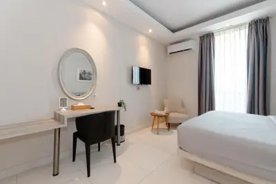 a bedroom with a bed and a desk and a mirror at Bustle Base Coliving and Coworking Space in Legian