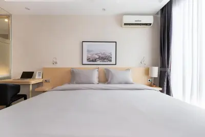 a bedroom with a large white bed and a desk at Bustle Base Coliving and Coworking Space in Legian