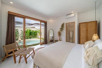 a bedroom with a bed and a view of a pool at Nooky 1 - 2BR Villa with HUGE Pool in Kerobokan