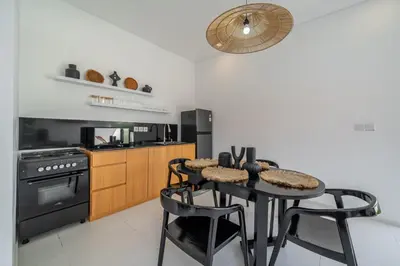 a kitchen with a table and chairs and a stove at Nooky 1 - 2BR Villa with HUGE Pool in Kerobokan