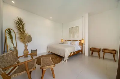 a bedroom with a bed and a table and chairs at Nooky 1 - 2BR Villa with HUGE Pool in Kerobokan