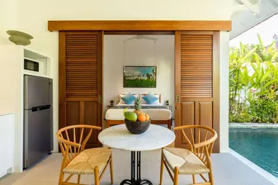 a room with a bed and a table and chairs at Paradise in the heart of Seminyak, 1-BR Pool-Villa in Seminyak
