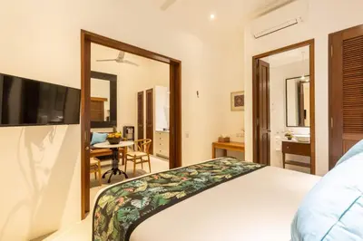 a bedroom with a bed and a table in a room at Paradise in the heart of Seminyak, 1-BR Pool-Villa in Seminyak