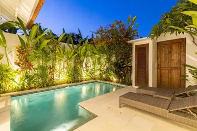 a swimming pool with two chairs next to a house at Paradise in the heart of Seminyak, 1-BR Pool-Villa in Seminyak