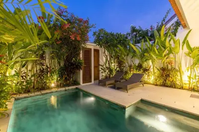 a swimming pool with two chairs next to a house at Paradise in the heart of Seminyak, 1-BR Pool-Villa in Seminyak