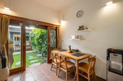 a dining room with a wooden table and chairs at Cozy 2 Bedroom Villa in Seminyak with private Pool in Seminyak