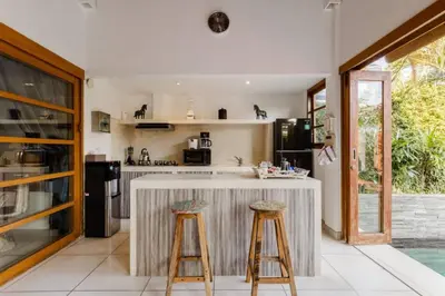 a kitchen with a counter and two stools at Luxurious and Cozy King Beds, Pool, closed living room in Kuta
