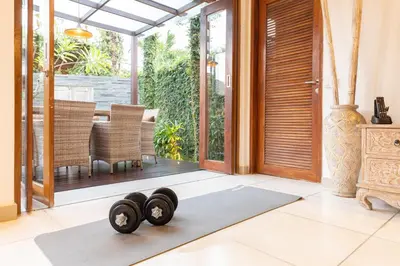 a yoga mat with two dumbbells on the floor in a living room at Luxurious and Cozy King Beds, Pool, closed living room in Kuta