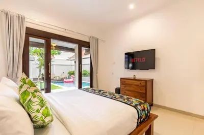 a bedroom with a large bed and a tv at Seminyak lush tropical paradise close to Eatstreet in Seminyak