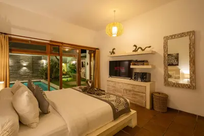 a bedroom with a bed and a tv and a mirror at Villa private Pool in Seminyak, Car Park fast WIFI in Kuta