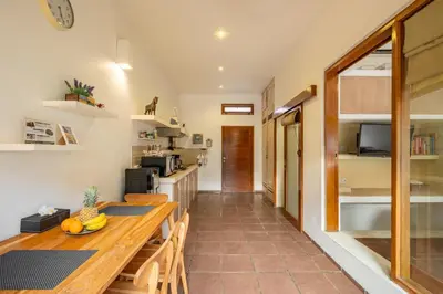 a kitchen and dining room with a wooden table at Villa private Pool in Seminyak, Car Park fast WIFI in Kuta