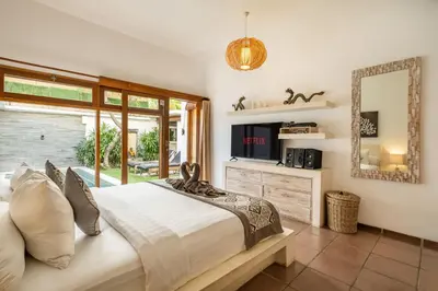 a bedroom with a large bed and a window at Villa private Pool in Seminyak, Car Park fast WIFI in Kuta