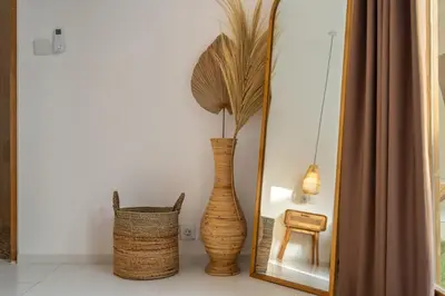 a vase sitting in front of a mirror at Nooky 2 - PROMO Seminyak - 2 BDR - Brand NEW Villa - HUGE Pool in Kerobokan