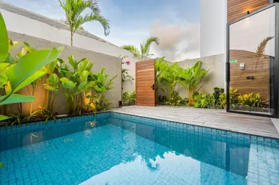 a swimming pool in the backyard of a house with a villa at Casa Tropicale Seminyak in Seminyak