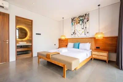 a bedroom with a large bed and a sink at Casa Tropicale Seminyak in Seminyak