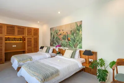 two beds in a room with a painting on the wall at 4BR Villa with Large Pool at Seminyak Beach in Seminyak