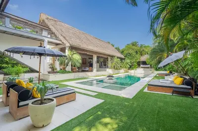 a backyard with a swimming pool and a house at 4BR Villa with Large Pool at Seminyak Beach in Seminyak