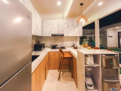 a kitchen with wooden cabinets and a counter top at Villa Zanetta By Bali Asia Villa in Kerobokan