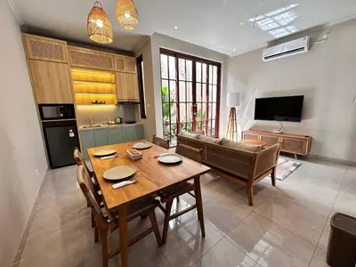 a living room with a table and a couch at Putu Soemantri Four Persons Villas in Denpasar
