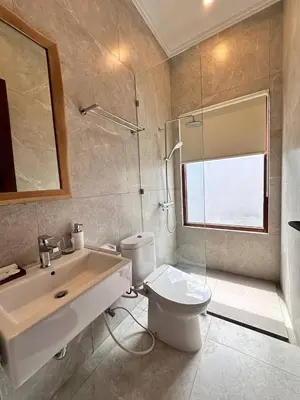 a bathroom with a toilet and a sink and a shower at Putu Soemantri Four Persons Villas in Denpasar