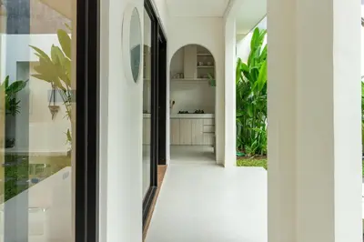 a hallway of a house with white walls and plants at Chic modern villa, 5 minute walk to Legian beach in Legian