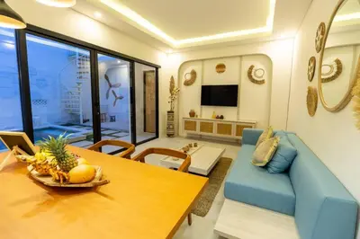 a living room with a table and a blue couch at Chic modern villa, 5 minute walk to Legian beach in Legian
