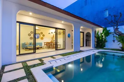 a villa with a swimming pool and a living room at Chic modern villa, 5 minute walk to Legian beach in Legian