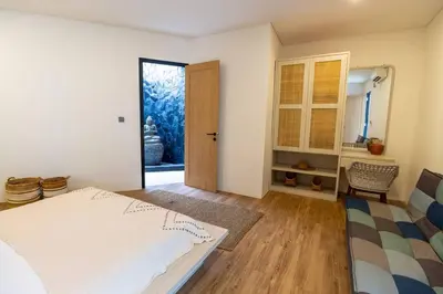 a white bedroom with a bed and a door at Chic modern villa, 5 minute walk to Legian beach in Legian