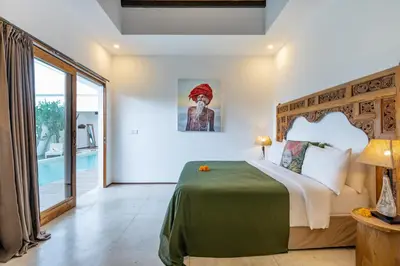 a bedroom with a bed and a large window at Villa Wamwui by DreamAwayBali in Seminyak