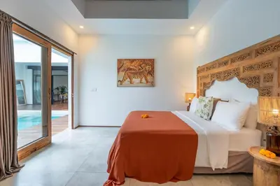 a bedroom with a large bed and a pool at Villa Wamwui by DreamAwayBali in Seminyak