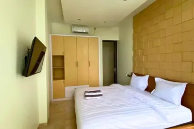 a bedroom with a large white bed with a tv on it at Cakrawala 3 Bedroom Villa in Jimbaran
