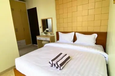 a bed with a pair of towels sitting on it at Cakrawala 3 Bedroom Villa in Jimbaran