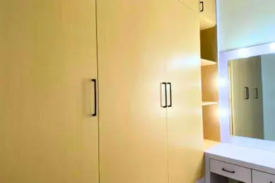 a bathroom with yellow cabinets and a mirror at Cakrawala 3 Bedroom Villa in Jimbaran