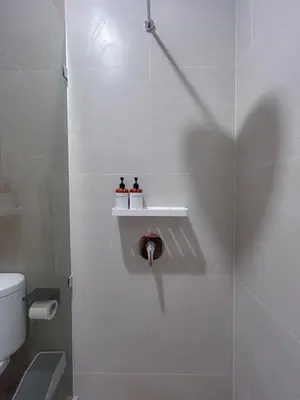 a bathroom with a shower stall with a toilet at Kaman Bali Guesthouse in Seminyak